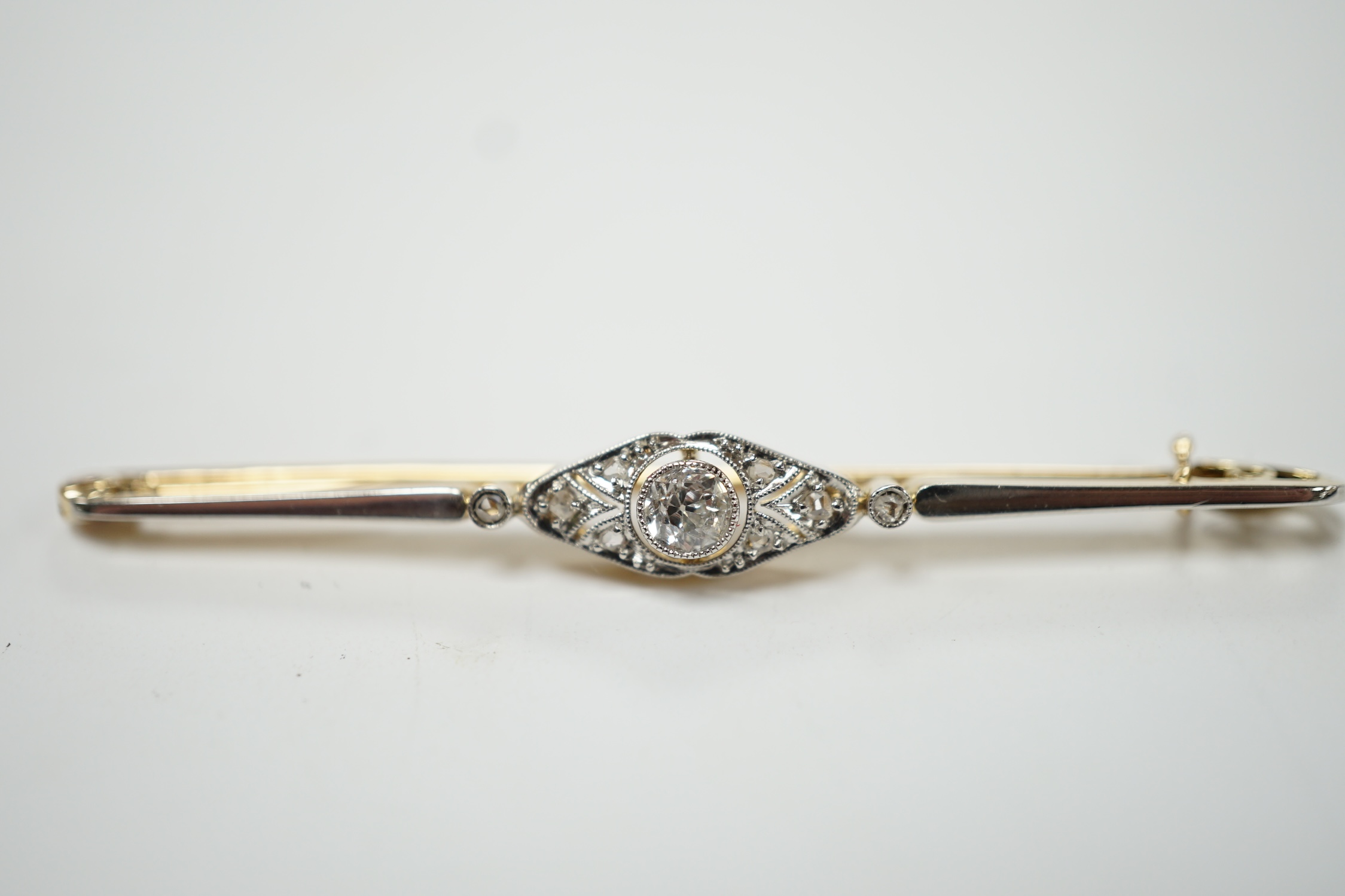 An Edwardian yellow metal and diamond cluster set bar brooch, 55mm, gross weight 3.6 grams. Condition - good